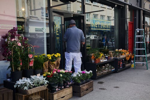 A Man Standing on the Front of a Flower Shop