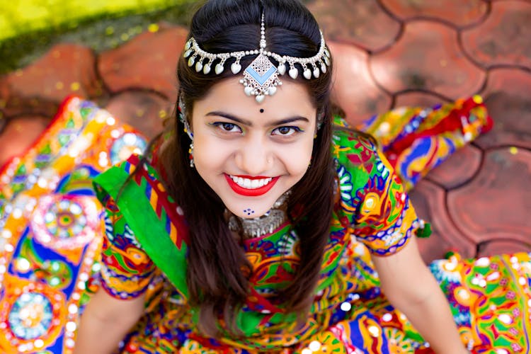 Sitting Smiling Woman Wearing Coloured Dress