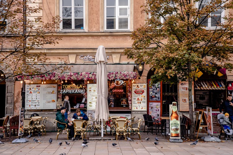 People And Pigeons Near Cafe In Poland