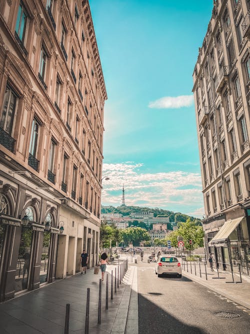 Urban Street between Buildings with the View of a Tower in Distance 