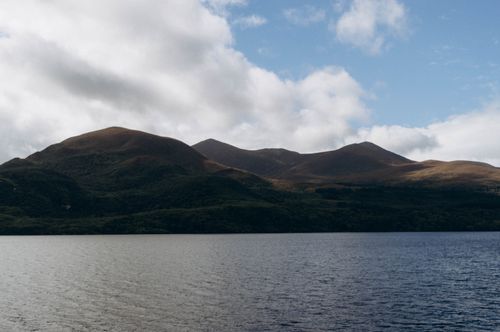 Free A scenic view of mountains and lake under a partly cloudy sky, perfect for nature lovers. Stock Photo
