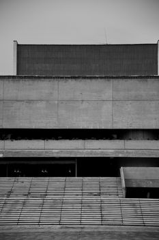 A monochrome image capturing the stark lines and geometry of a Brutalist concrete facade.. monochrome, image, capturing