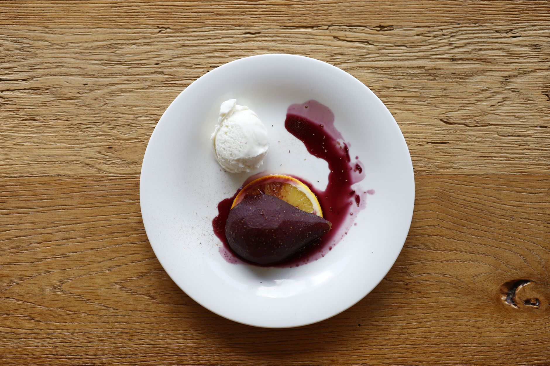 Close-up of wine poached peaches with ice cream and nutmeg garnish