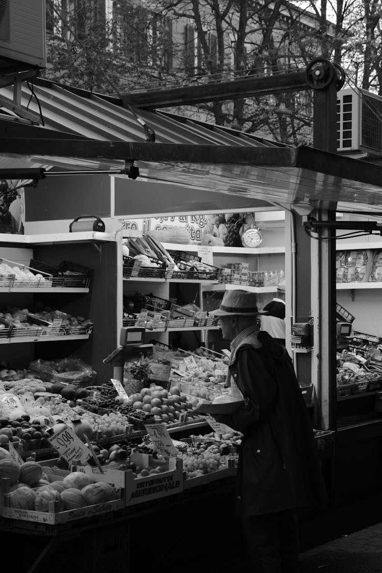 Black And White Shot Of A Man Shopping At A Market Stall