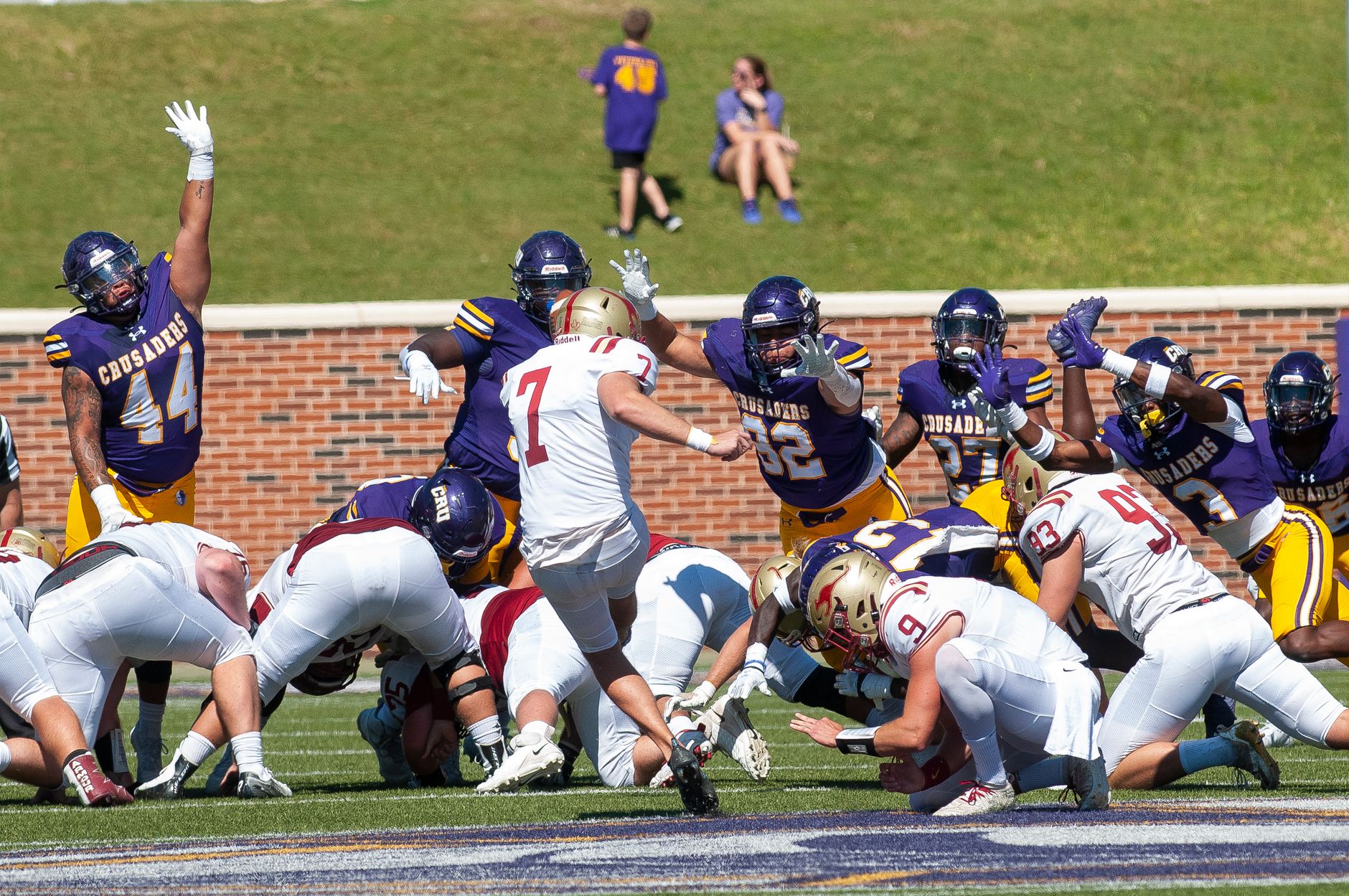 Dynamic action shot of an American football game with players in colorful gear.