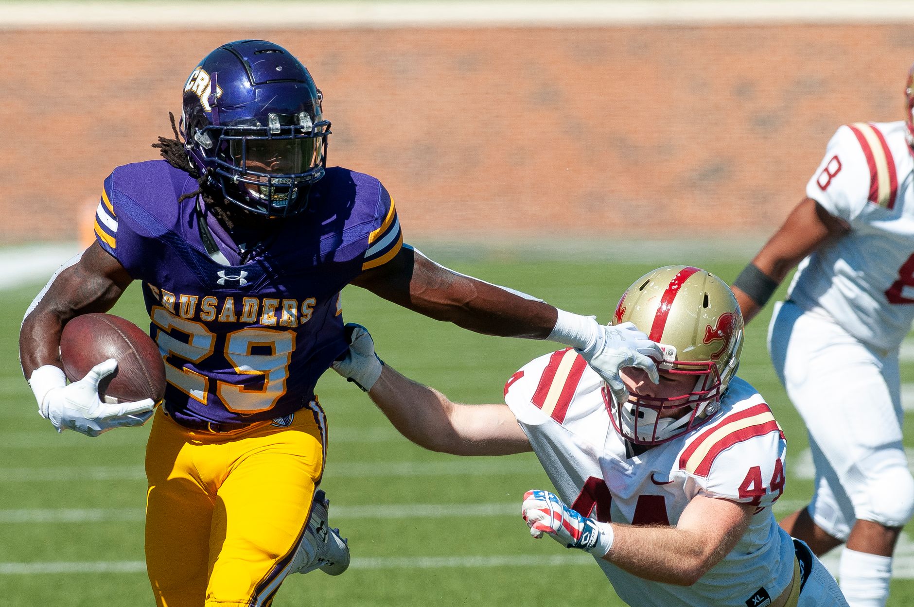 college football running back cutting through a crowded defensive front during a tense autumn afternoon