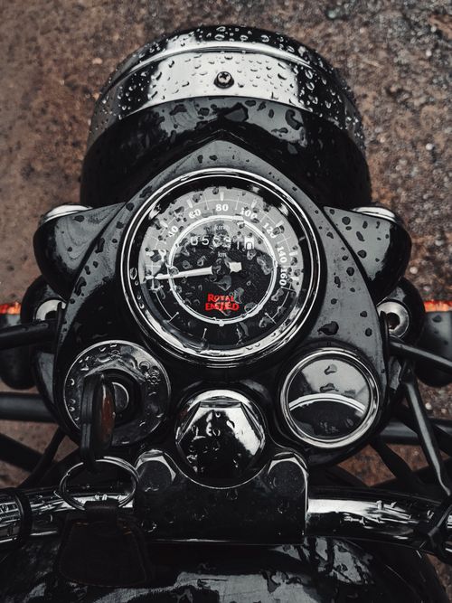 Free Detailed view of a motorcycle speedometer covered with raindrops, showcasing a wet and dynamic feel. Stock Photo