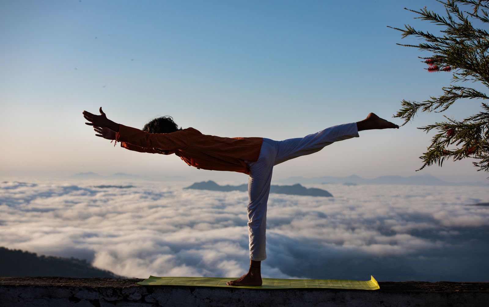 Yoga practitioner holding Warrior pose outdoors to strengthen and tone the thighs