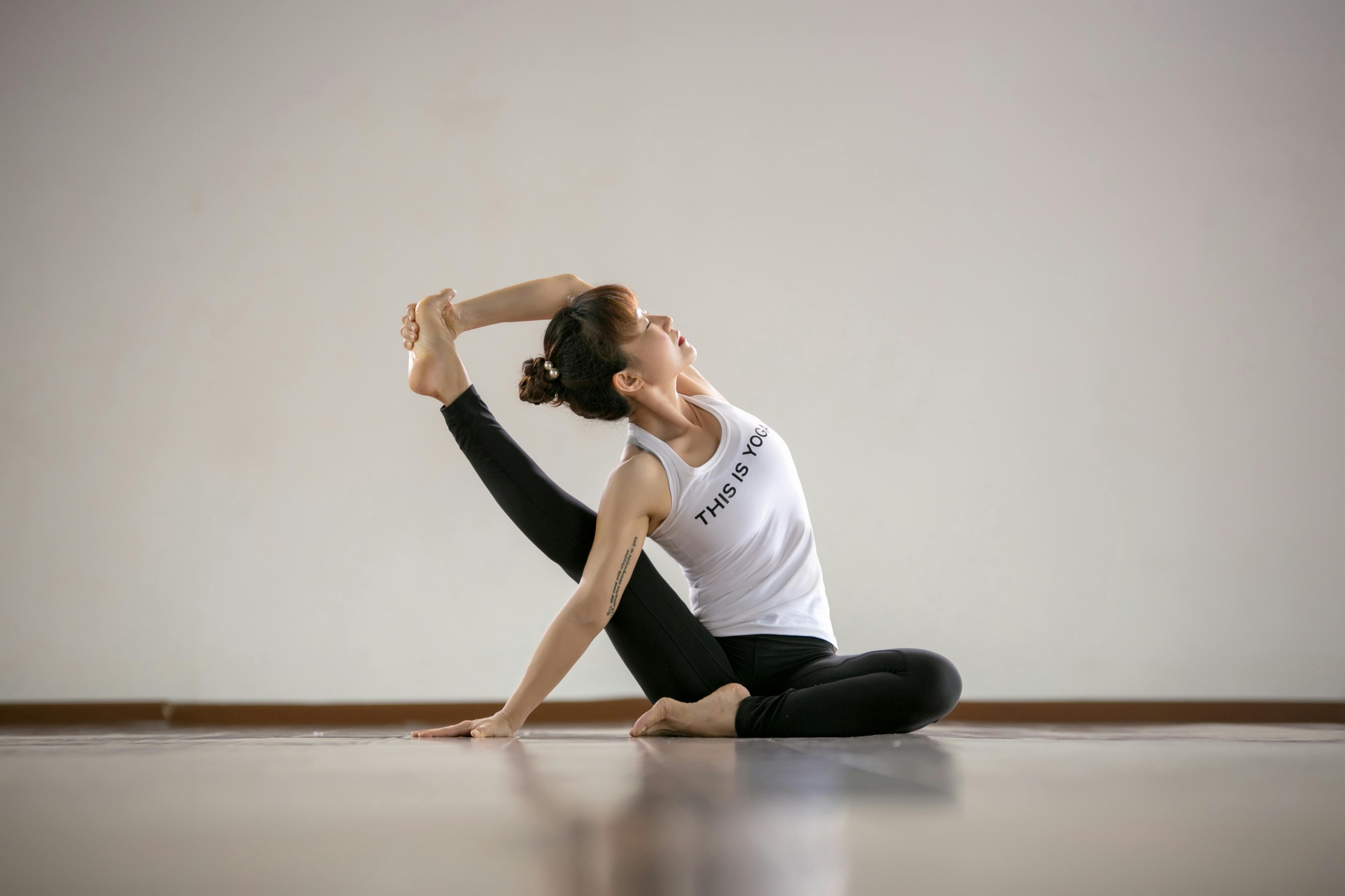 A woman practicing yoga indoors, showcasing flexibility and balance.