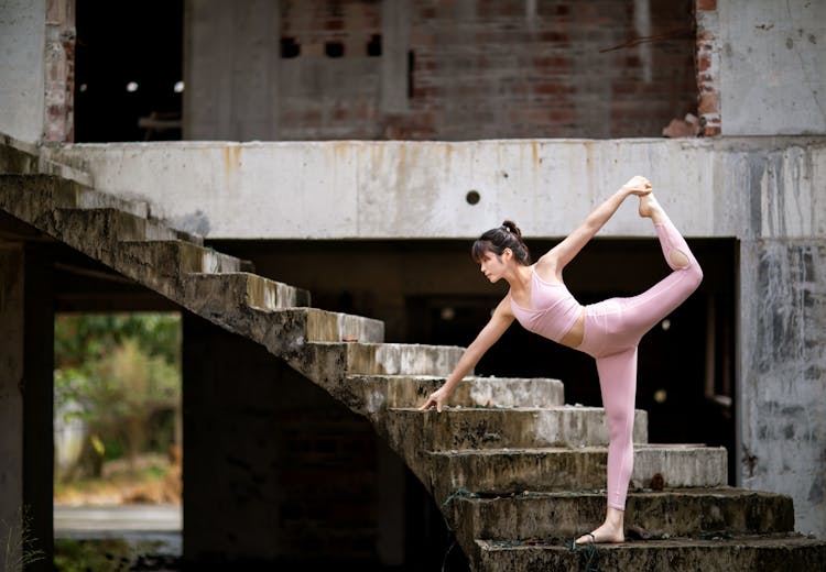 Young Woman Doing A Stretching Exercise On Stairs 