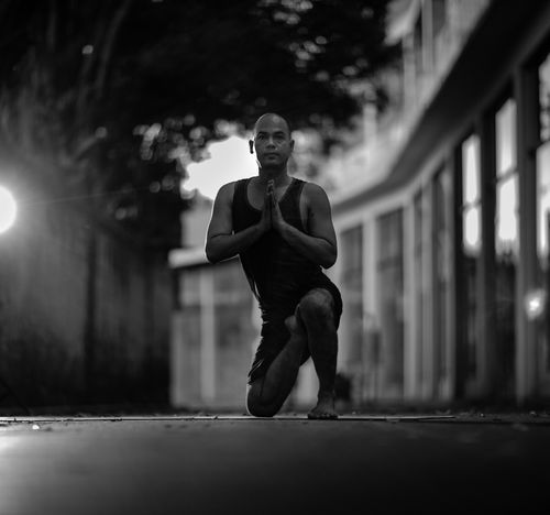 Free A man practicing yoga on the street in a black and white setting. Stock Photo