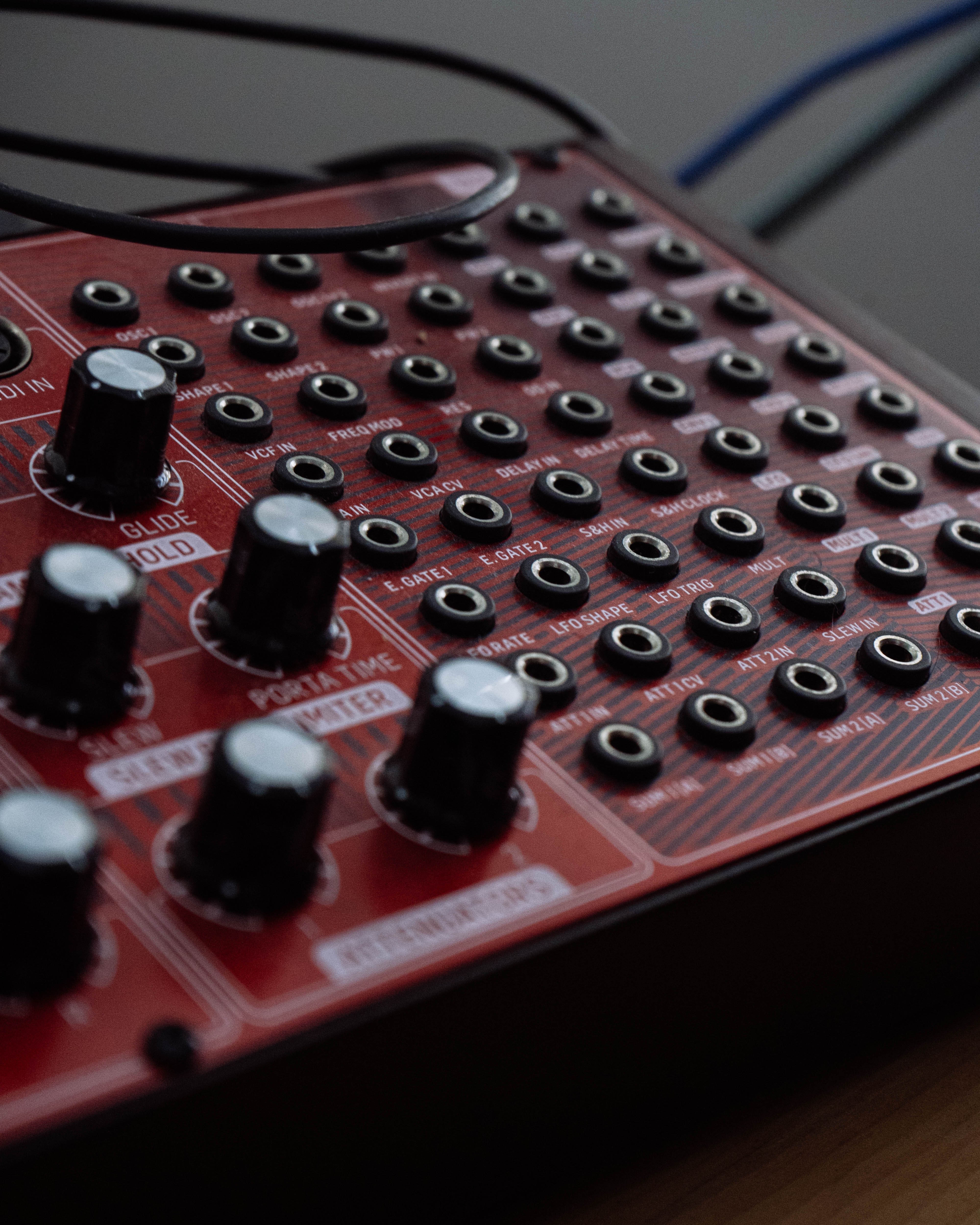 Detailed view of a red audio mixing console with knobs and ports for sound production.
