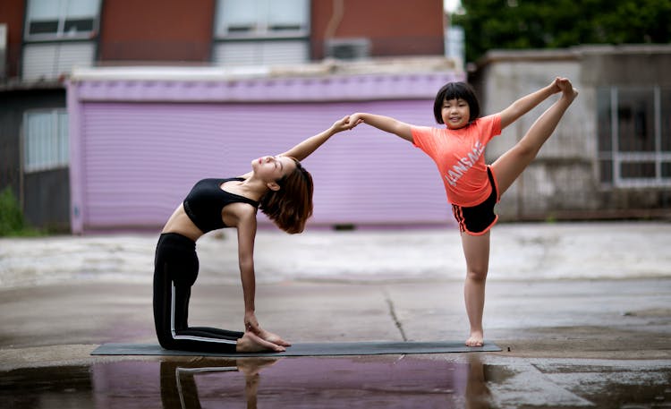 Woman And Girl Stretching On Street