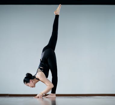 Flexible woman in yoga pose demonstrates balance and strength indoors. Perfect for wellbeing and fitness themes.
