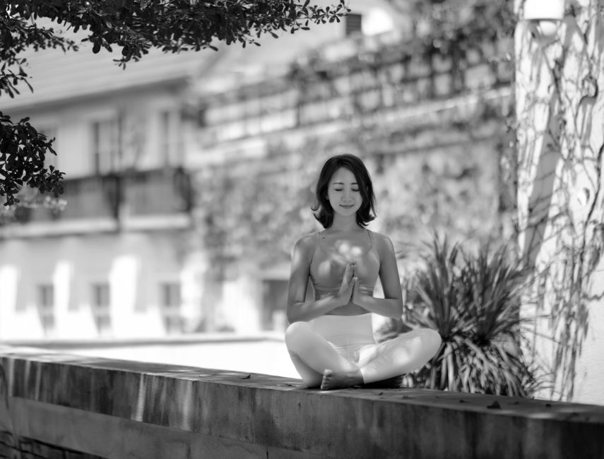 Woman meditating outdoors in grayscale, eyes closed, in a peaceful yoga pose. Woman meditating outdoors in grayscale, eyes closed, in a peaceful yoga pose.