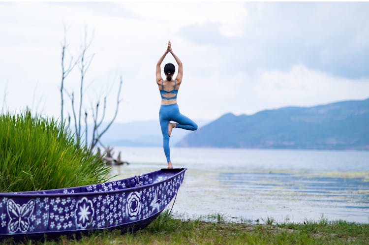 Woman In Blue Active Wear Standing On The Edge Of A Boat