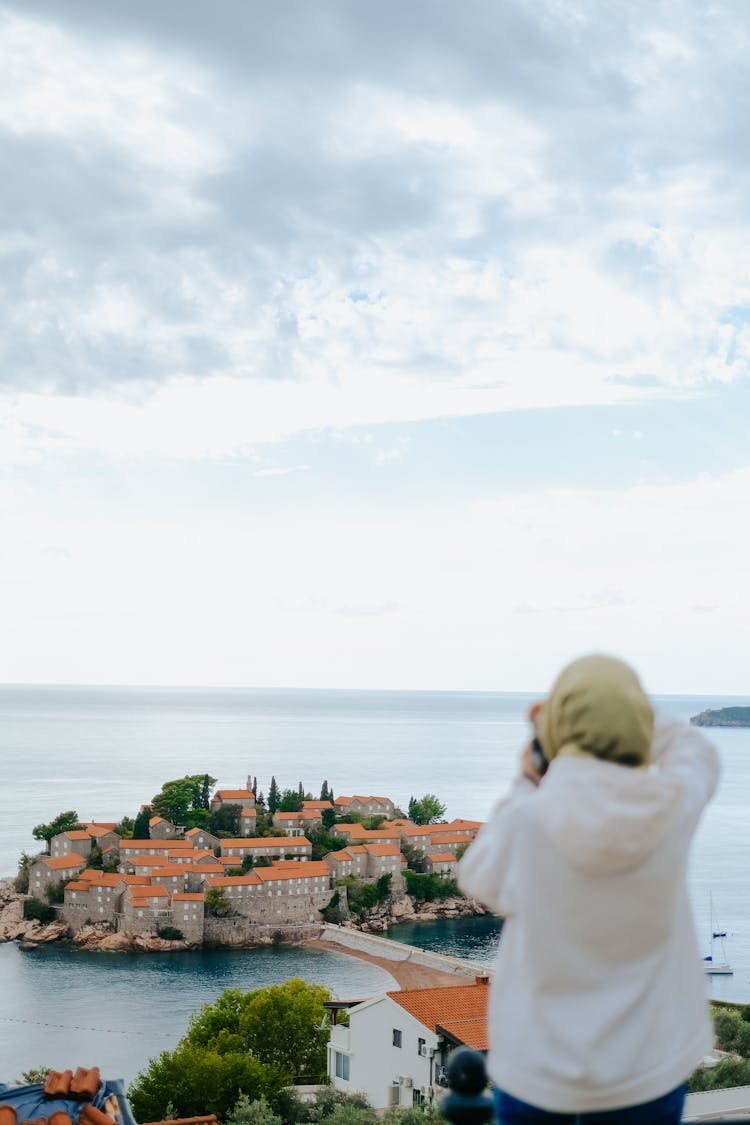 Person Taking Photo Of City On Island