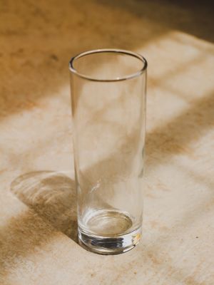 Empty tall glass cylinder on a stone surface, photo by Teguh Sugi on Pexels