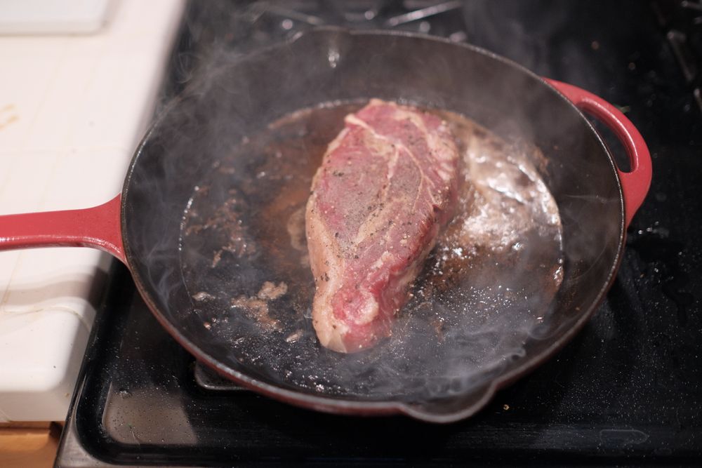A seasoned chop searing in a cast-iron pan on the cooktop — Deane Bayas on Pexels