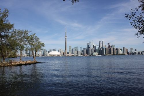 Free Scenic view of Toronto skyline featuring the iconic CN Tower across a serene lake. Stock Photo