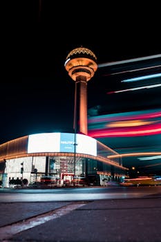 Night view of the vibrant and illuminated Atakule Tower in Ankara with long exposure light trails.