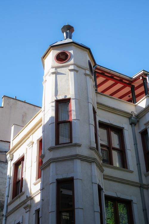 Free Low-angle view of a historic urban building showcasing unique architecture and round tower. Stock Photo