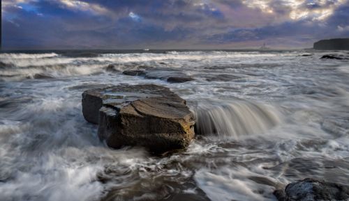 Free Majestic view of waves crashing over rocks along the scenic coastline at dusk. Stock Photo