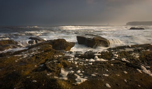 Free Captivating coastal scene featuring dramatic waves crashing over rocks under a moody sky. Stock Photo
