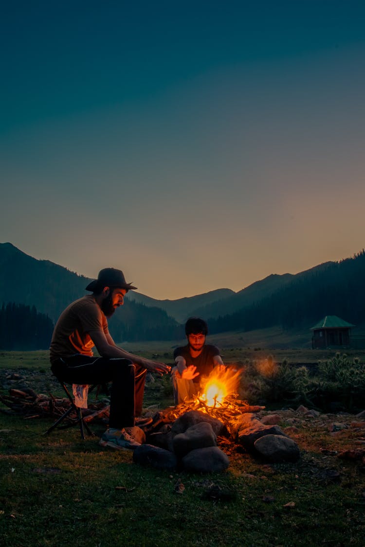 Two Men Sitting Near The Campfire