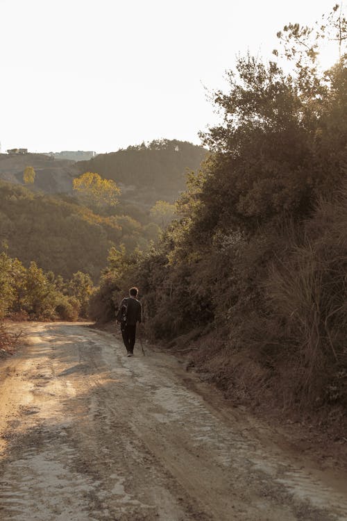 Person Walking on Dirt Road