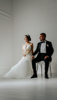 A bride and groom elegantly seated, capturing a classic and timeless wedding moment.