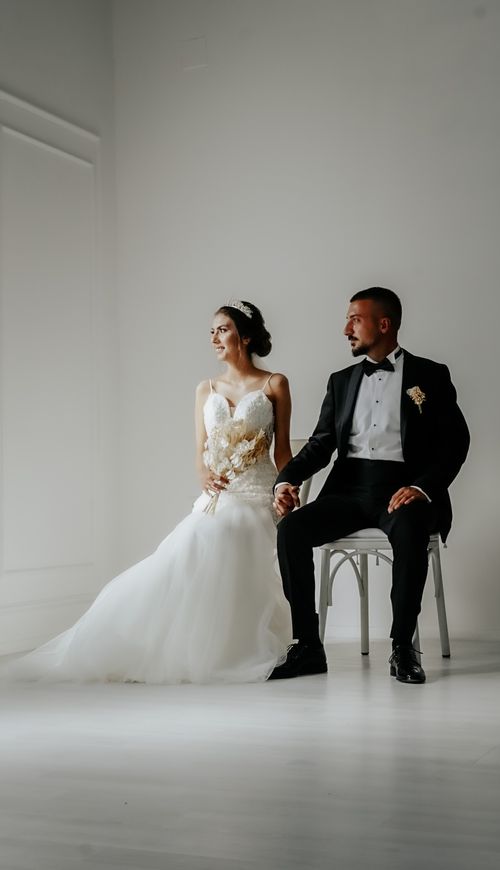 Free A bride and groom elegantly seated, capturing a classic and timeless wedding moment. Stock Photo