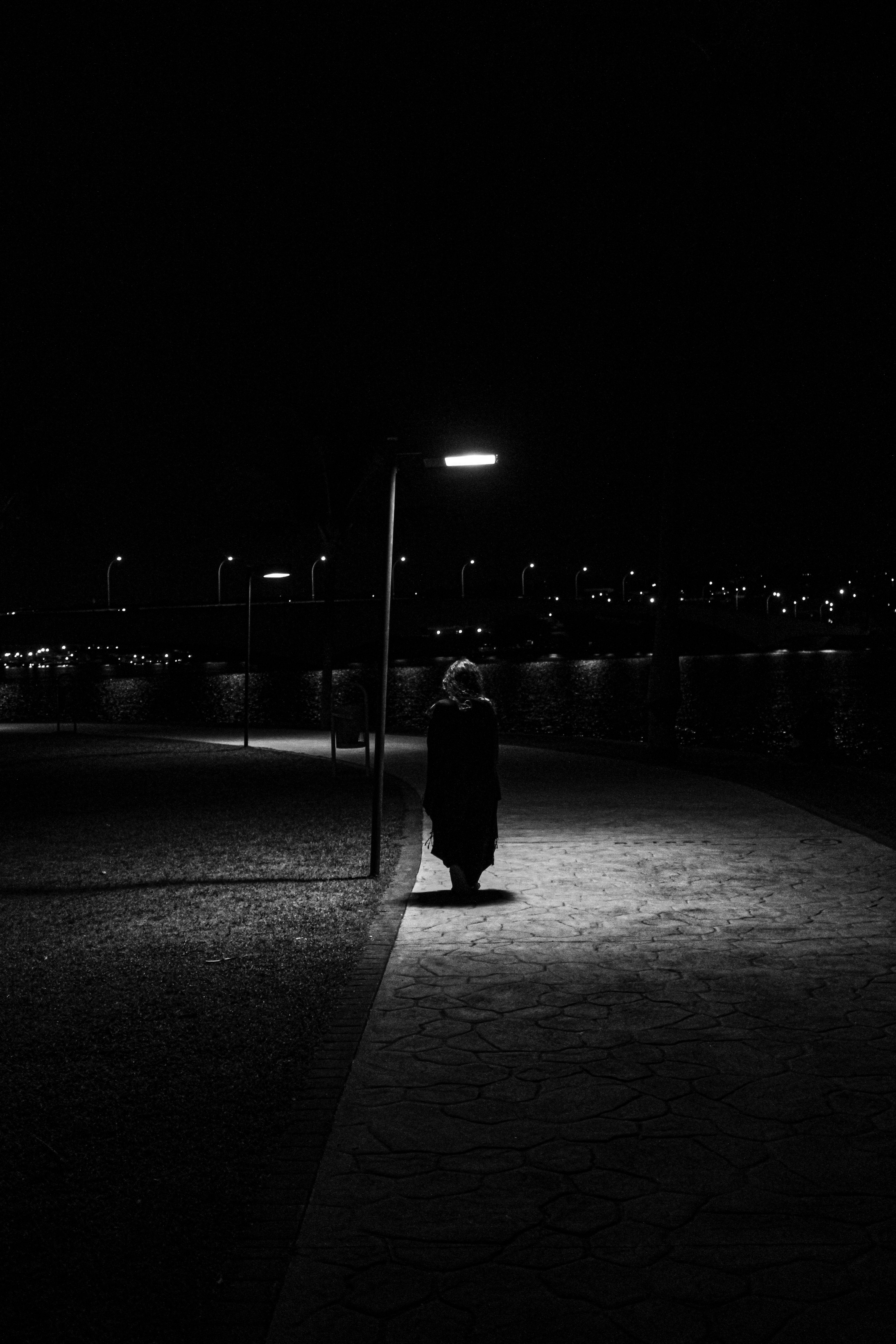 Grayscale Photo of a Person Walking by the Sea · Free Stock Photo