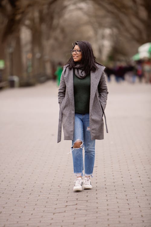 A Woman in Gray Coat and Blue Denim Jeans