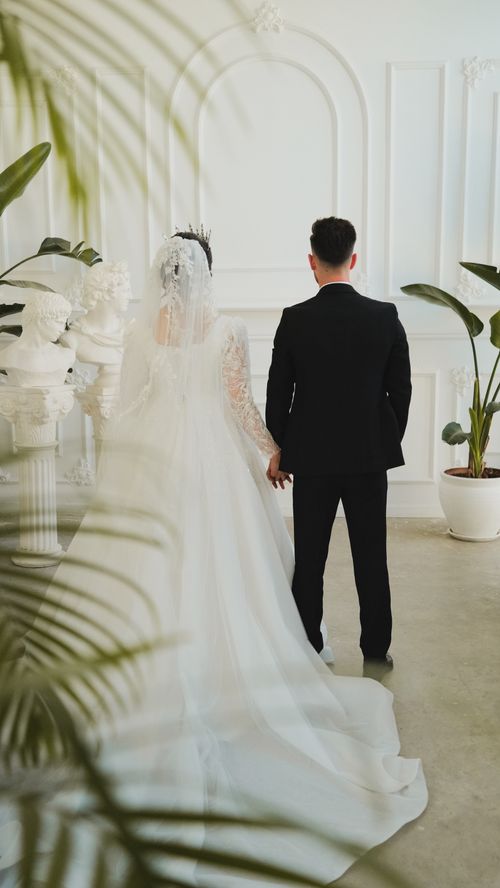 Free Bride and groom holding hands in a beautifully decorated indoor wedding setting. Stock Photo