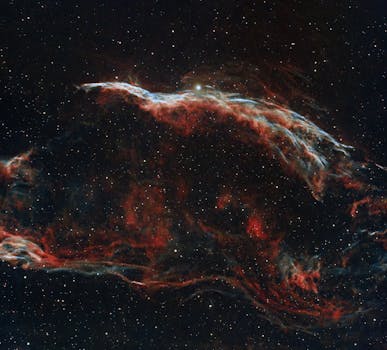 Explore the vibrant colors and patterns of the Veil Nebula captured in deep space.