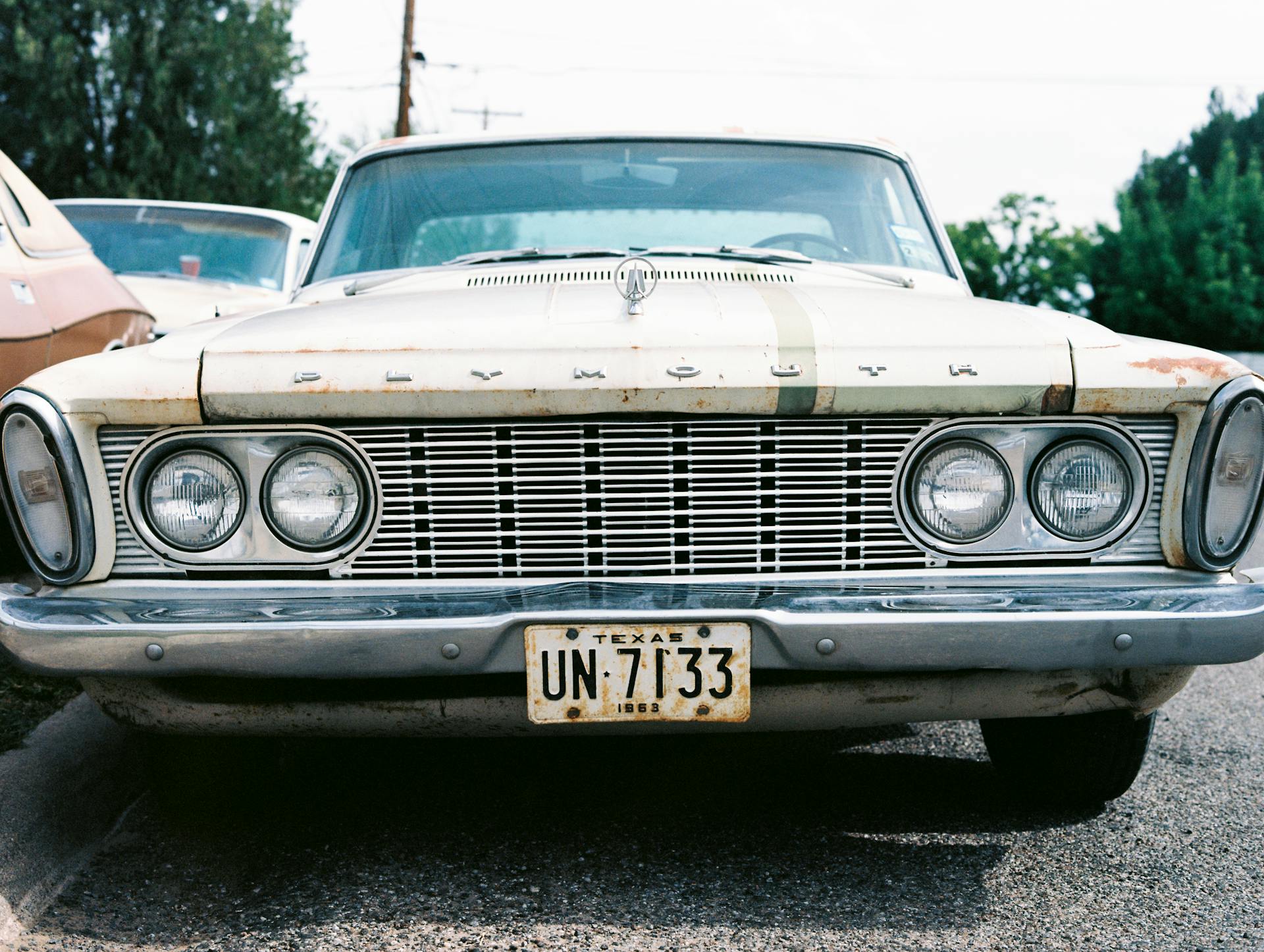 Close-up of a vintage Plymouth car with a Texas license plate parked outdoors.