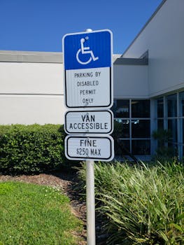 Accessible parking sign for disabled permits with van access in bright daylight.