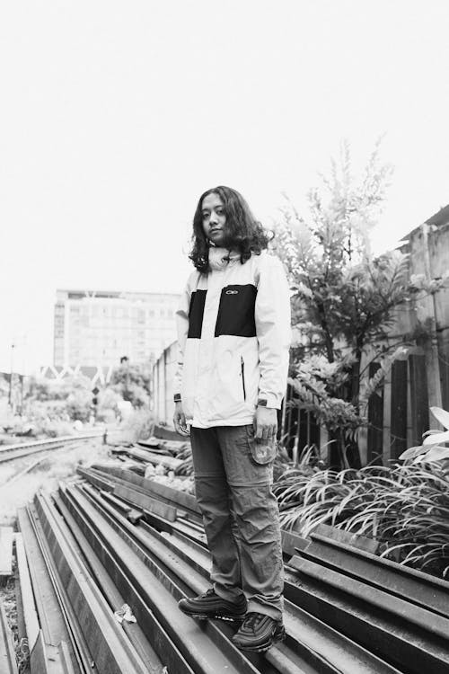 Girl in Casual Wear Standing on Tracks