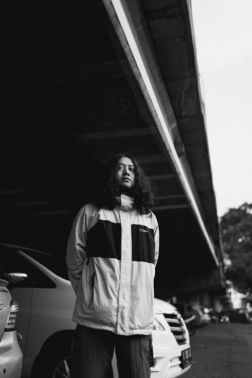 Grayscale Photo of Man with Long Hair Wearing Jacket