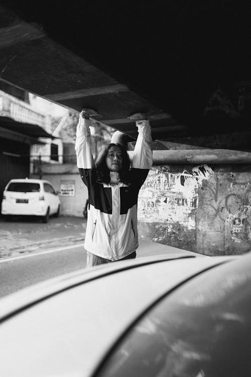 Monochrome Shot of a Person in Jacket Raising Both Hands