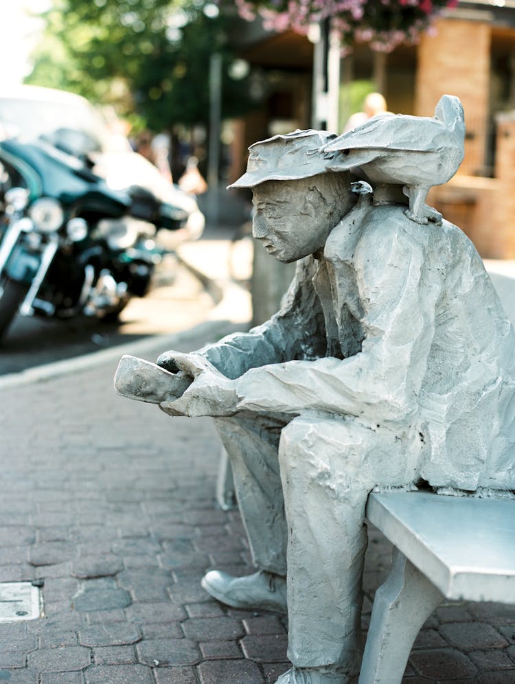 Aluminum Sculpture Of Man Sitting On A Bench Named The Traveler In Bend, Oregon