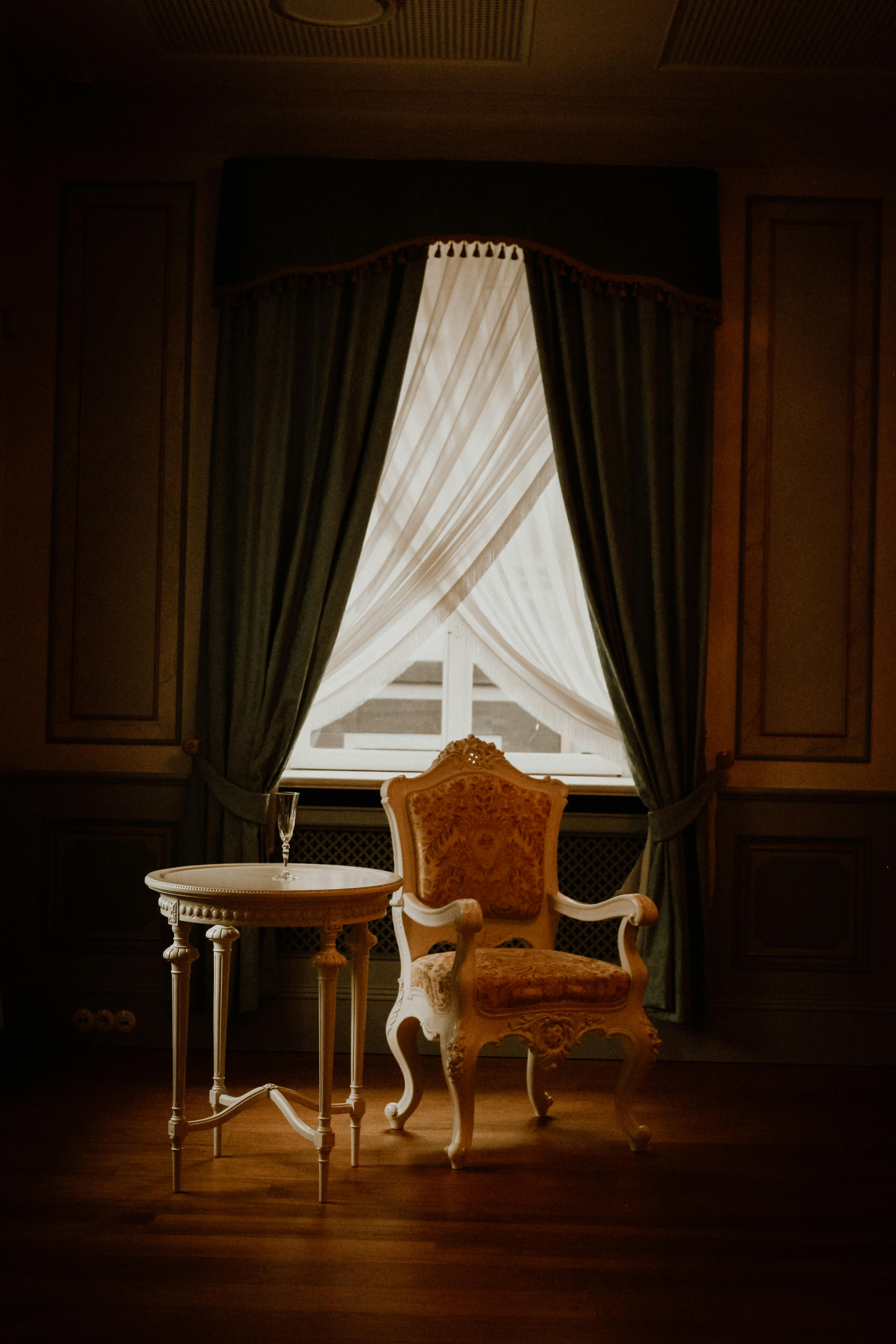 Luxurious vintage room showcasing an armchair by a window with elegant curtains in Riga, Latvia.