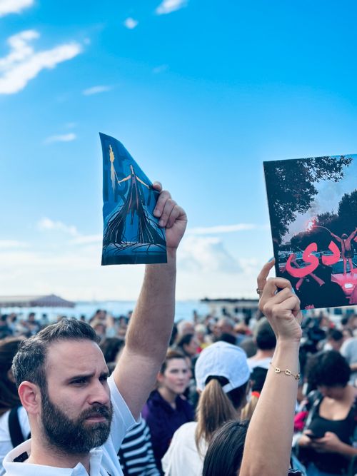 Free A diverse crowd in Istanbul holds protest signs under a bright blue sky. Stock Photo