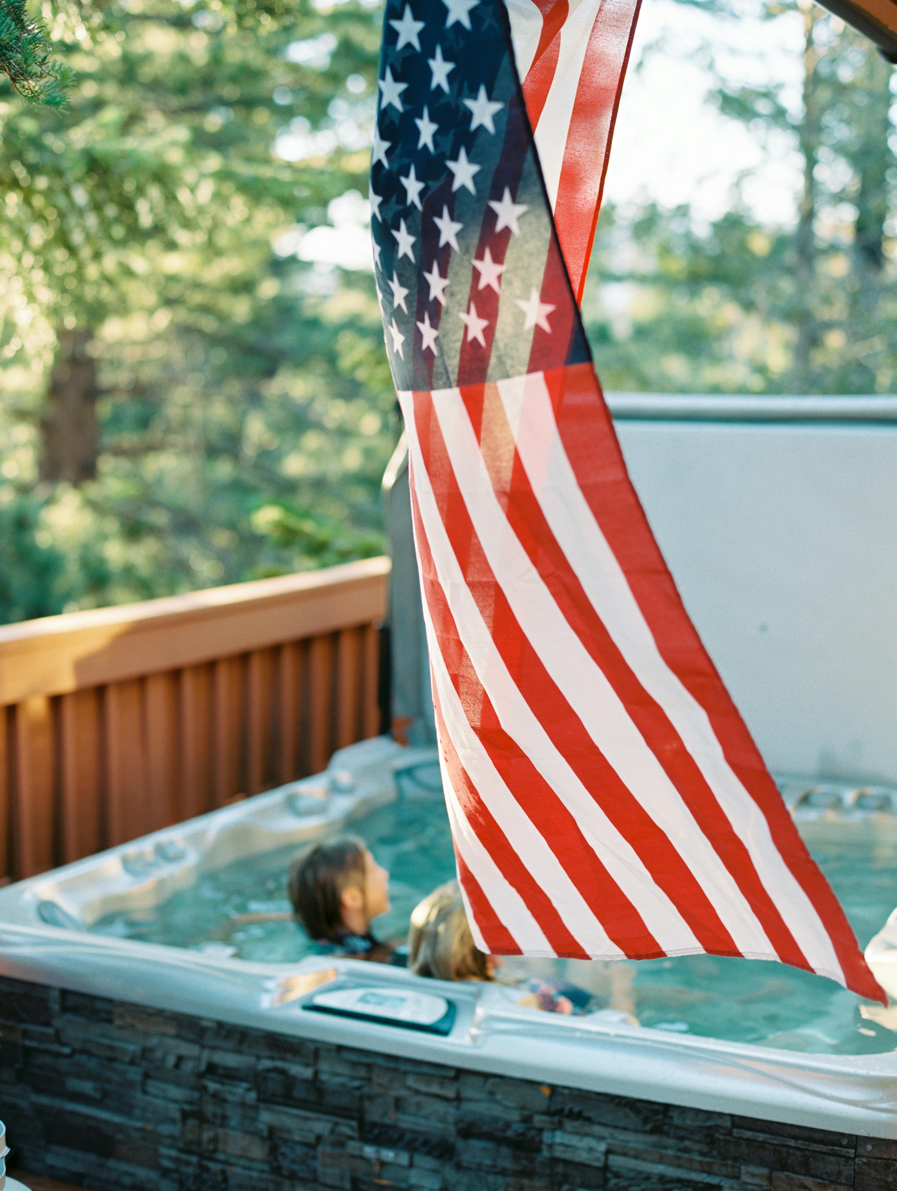 Women Sitting in Jacuzzi behind American Flag · Free Stock Photo