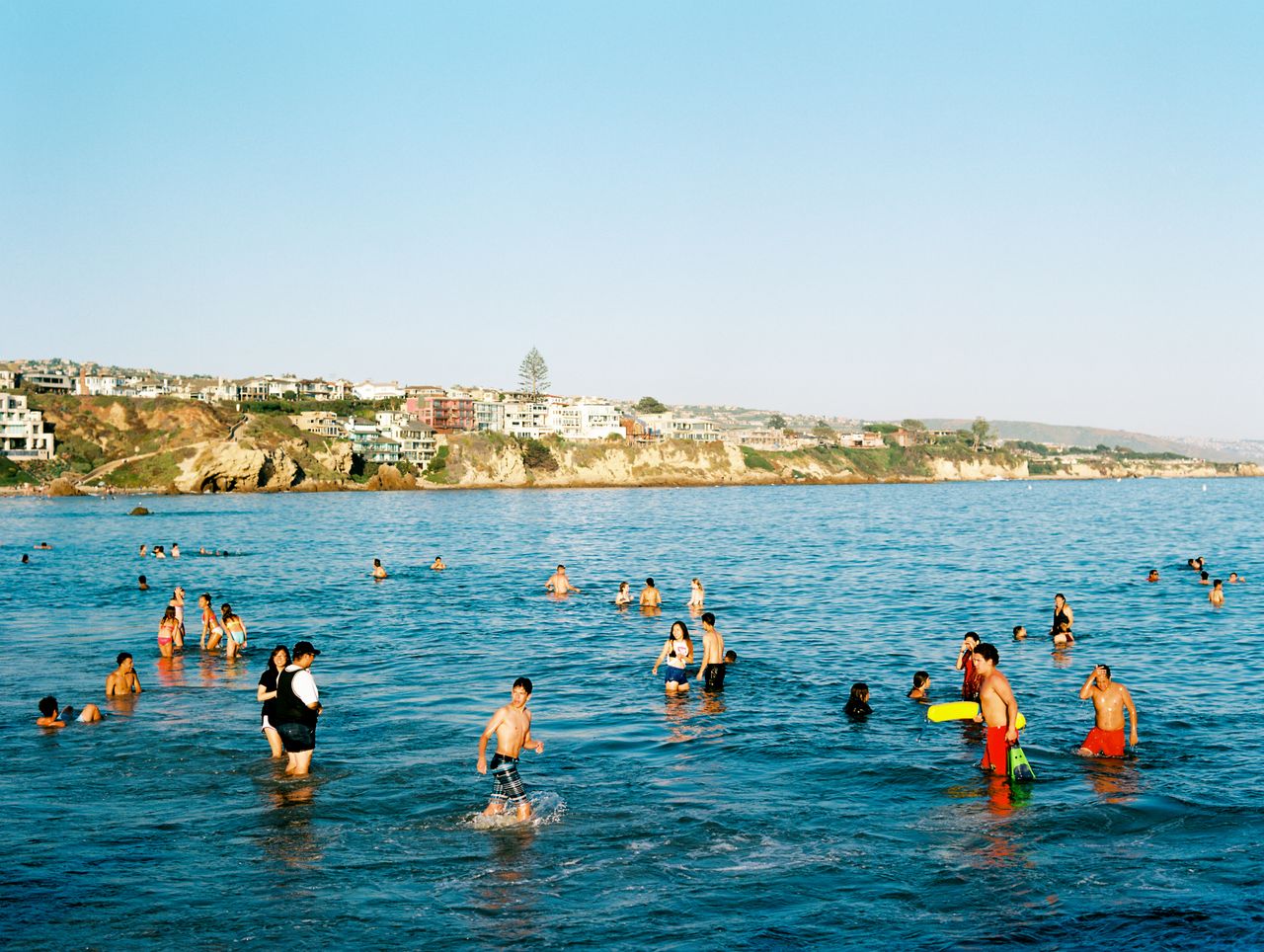 people enjoying a summer day swimming at newport beach california with
