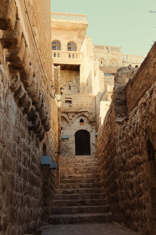 Free Discover a narrow stone alleyway in an ancient town, showcasing beautiful heritage architecture. Stock Photo