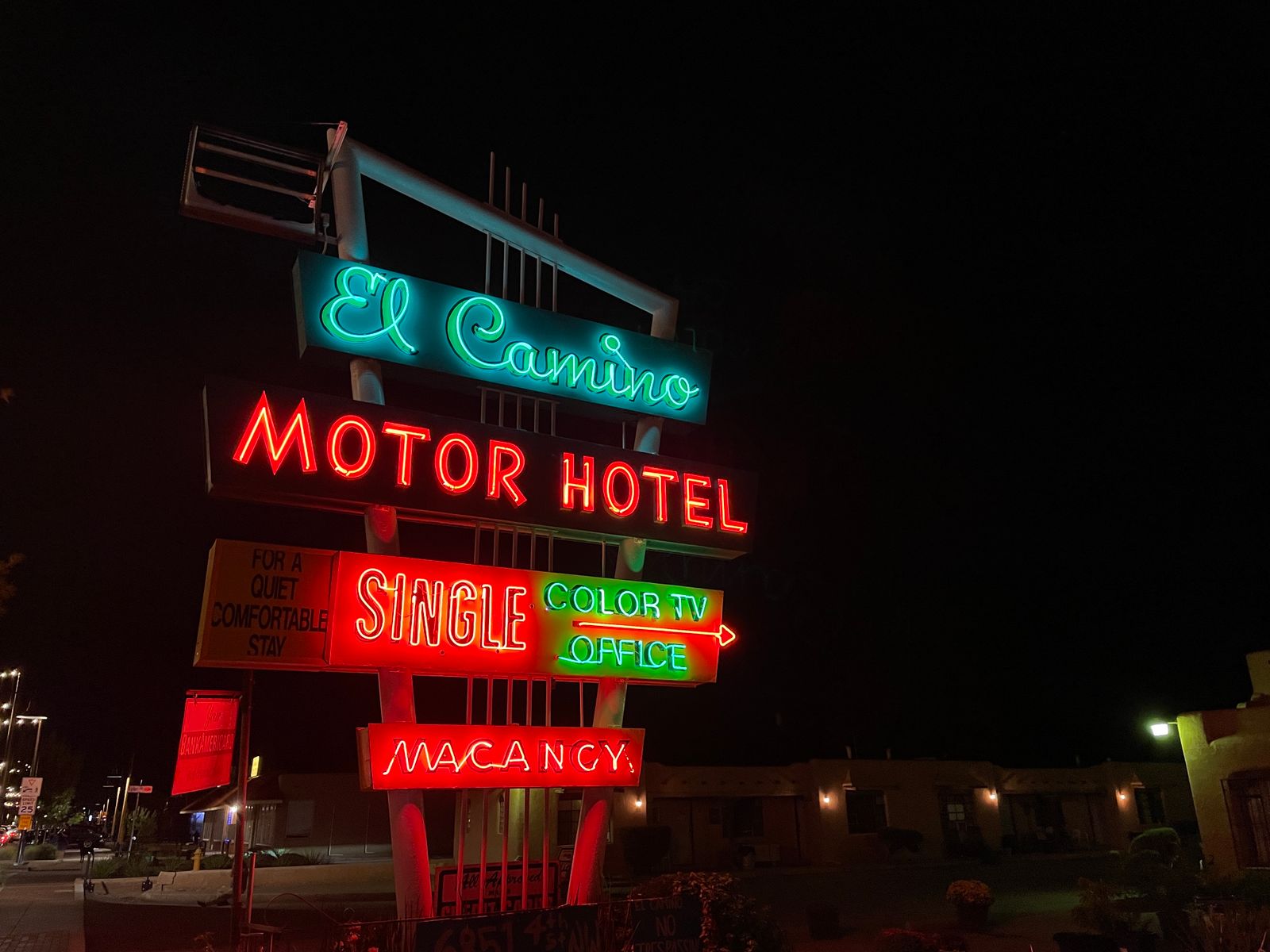 Vintage neon motel sign glowing at night along a roadside
