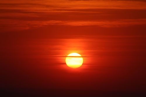 Free Captivating sunset scene with a glowing sun and vivid red sky, embodying serene natural beauty. Stock Photo