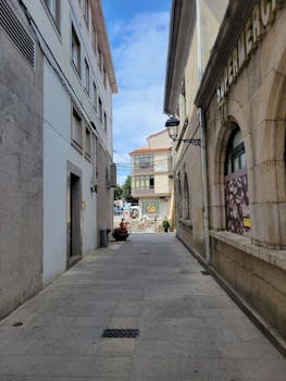 Explore the historic alleyways and architecture of Padrón, Galicia, Spain, showcasing traditional facades and a narrow street.